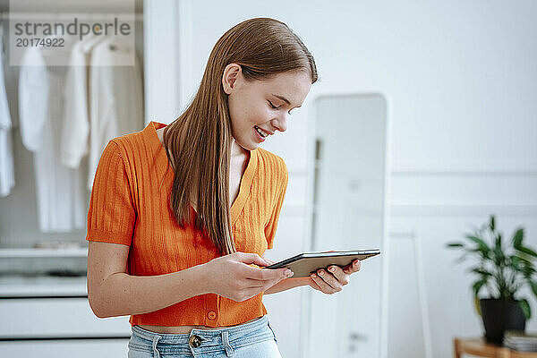 Lächelnde Frau  die zu Hause einen Tablet-PC benutzt