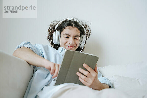 Lächelnder Mann mit Headset und Tablet-PC zu Hause
