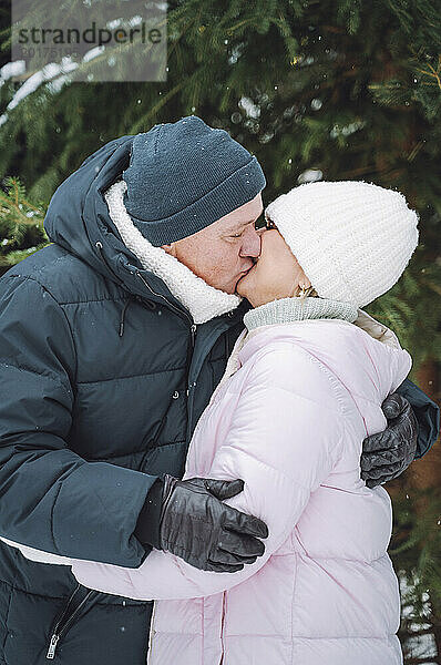 Affectionate mature couple kissing each other in winter