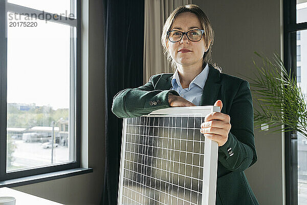 Ingenieur stützt sich im Büro auf Solarpanel