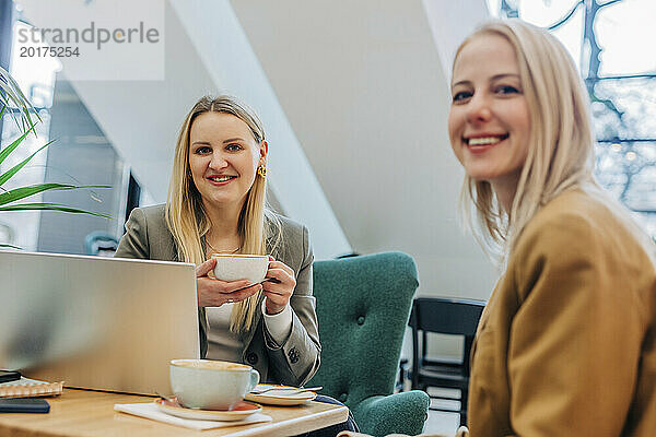 Lächelnde Geschäftsfrauen beim Kaffee im Café