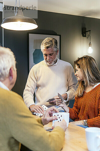 Reife Frau und Mann spielen zu Hause Karten