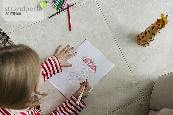Mädchen zeichnet zu Hause auf Papier