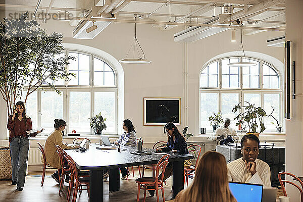 Gemischtrassiges Team männlicher und weiblicher Geschäftsleute  die im Coworking-Büro arbeiten