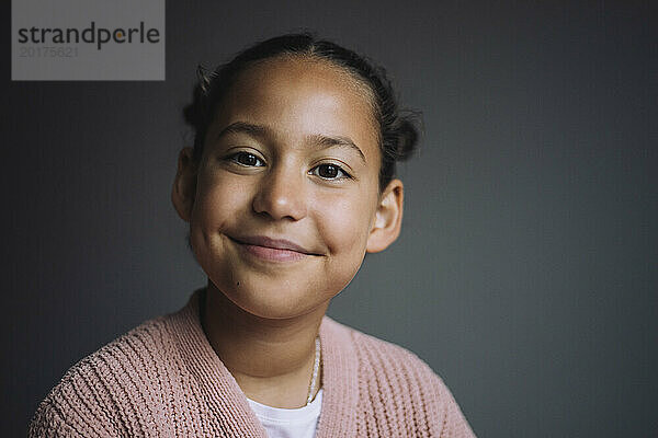 Porträt eines lächelnden Mädchens vor grauem Hintergrund
