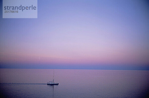 Australien. Queensland. Pazifik See. Einsamer Katamaran im Morgengrauen.