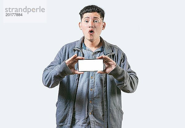 Überrascht Mann zeigt Handy Bildschirm isoliert. Erstaunlicher junger Mann zeigt eine Werbung auf dem Handy