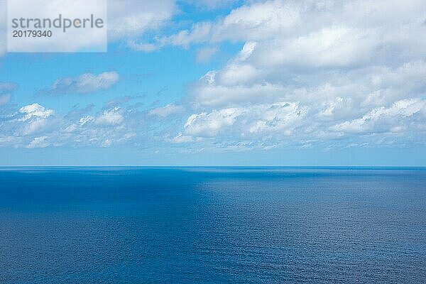 Ruhiges  weites  blaues Meer unter klarem  blauem Himmel mit vereinzelten weißen Wolken  ferner Horizont im Frühling  Frühjahr  winzige Segelboote und ein weit entferntes Schiff am Horizont  Mittelmeer an der Nordwestküste  Mallorca  Spanien  Europa