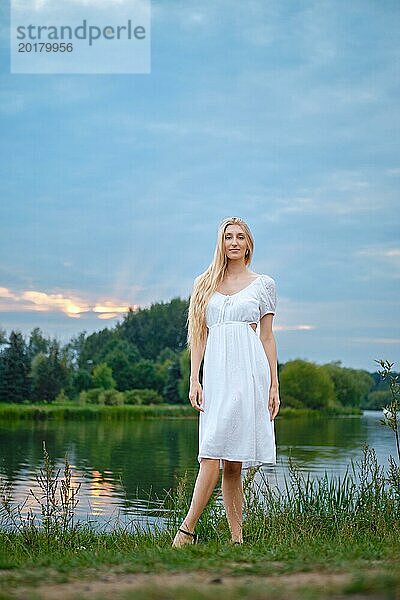 Fröhliche Frau am Abend am Fluss