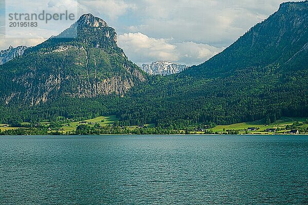 Berg und See mit Wiesen im Vordergrund unter bewölktem Himmel  Sankt Wolfgang  Wolfgangsee  Salzkammergut  Östereich