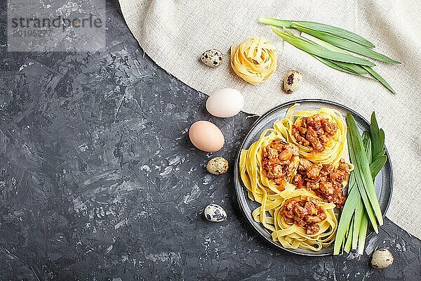 Tagliatelle Bolognese Nudeln mit Hackfleisch auf schwarzem Betonhintergrund. Draufsicht  flat lay  copy space