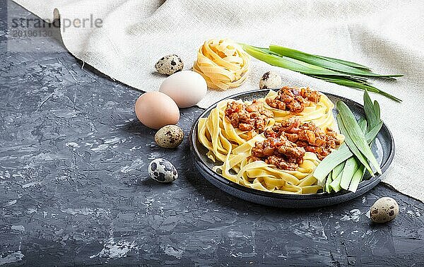 Tagliatelle Bolognese Nudeln mit Hackfleisch auf schwarzem Betonhintergrund. Seitenansicht  Nahaufnahme  Kopierbereich