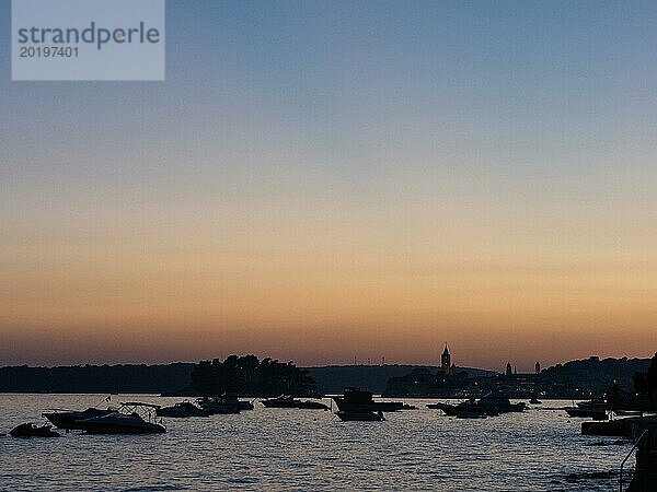 Boote ankern in einer Bucht  Kirchtürme  Abendstimmung nach Sonnenuntergang über Rab  Stadt Rab  Insel Rab  Kvarner Bucht  Kroatien  Europa