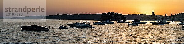 Boote ankern in einer Bucht  Silhouette von einem Kirchturm  Sonnenuntergang über Rab  Panoramaaufnahme  Stadt Rab  Insel Rab  Kvarner Bucht  Kroatien  Europa