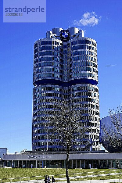 BMW-Hauptgebäude  bekannt als 'Vierzylinder'  vor klarem Himmel mit Bäumen im Vordergrund  BMW WELT  München  Deutschland  Europa