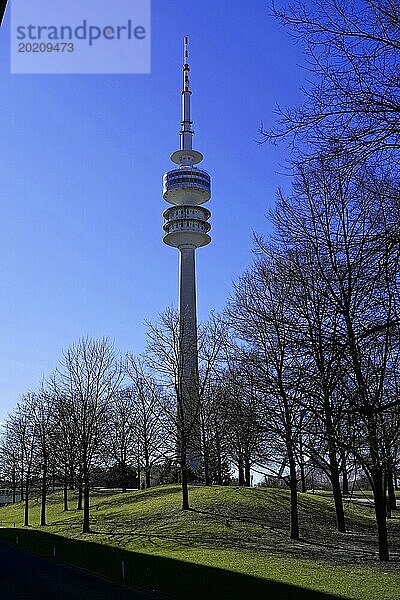 Fernsehturm ragt hinter kahlen Bäumen gegen einen klaren blaün Himmel empor  BMW WELT  München  Deutschland  Europa
