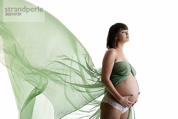 Schöne schwangere junge Frau mit wehendem Stoff. vor weißem Hintergrund