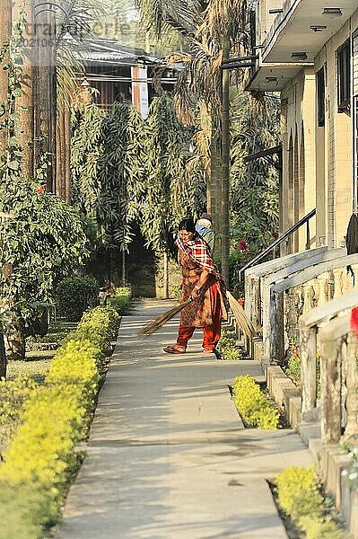 Zwei Personen bei der Gartenarbeit in einem Hotelkorridor  Chitwan Nationalpark  Nepal  Asien
