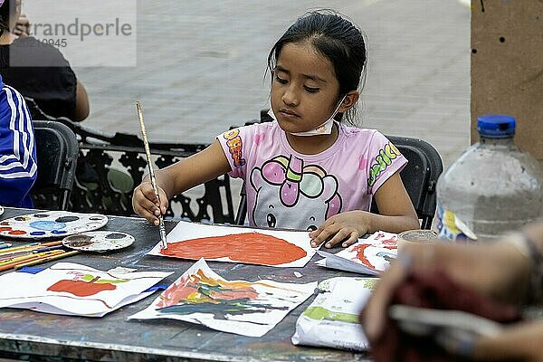 Oaxaca  Mexiko  Studenten malen in einem temporären Kunstkurs auf dem Zocalo. Ein Mädchen malt ein Herz am Tag vor dem Valentinstag  Mittelamerika