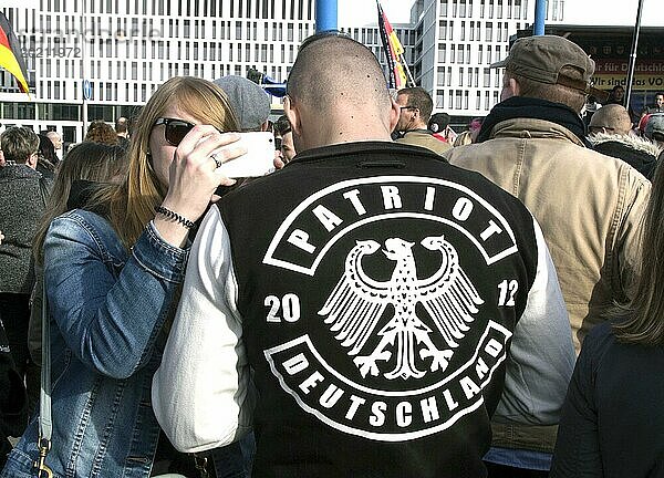 Ein Teilnehmer der Merkel muss weg Demo trägt eine Jacke mit der Aufschrift Patriot . Demonstration von rechtspopulistischen und rechtsextremen Teilnehmern  zu denen auch Anhänger von NPD  Pegida  Reichsbürgern  Hooligans  Landsmannschaften und Identitären gehören  Berlin  04.03.2017