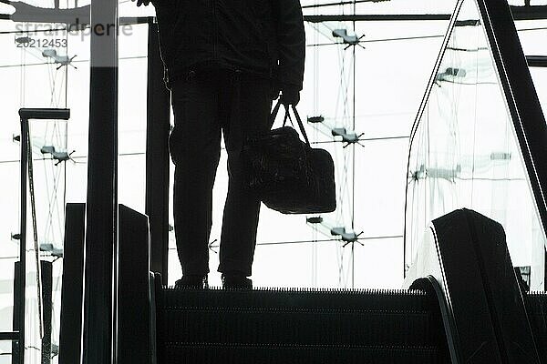 Silhouette von einem Mann mit einer Tasche auf einer Rolltreppe im Berliner Hauptbahnhof  26.09.2016