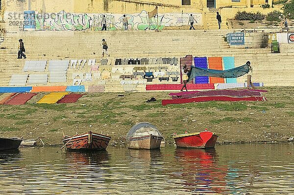 Bunte Wäsche  die neben einem Flussufer trocknet  mit Graffiti im Hintergrund  Varanasi  Uttar Pradesh  Indien  Asien