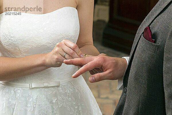 Die Braut schiebt dem Bräutigam während der Trauung den Ehering über den Ringfinger  14.06.2016