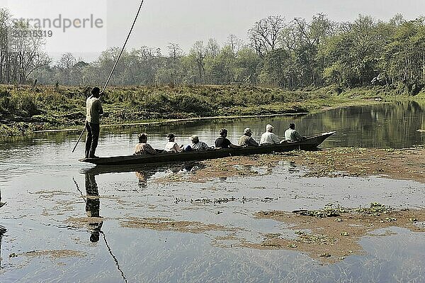 Ruhige Bootsfahrt mit Passagieren über einen friedlichen Fluss mit Spiegelungen  Chitwan Nationalpark  Bhairahawa  Nepal  Asien