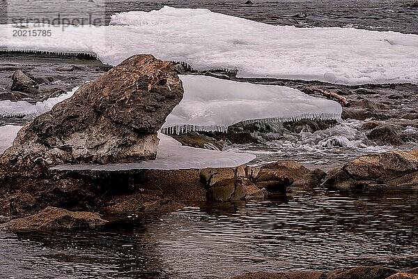 Zu Felsblöcken gefrorene Eisplatten  die sich über fließendes Wasser in einem Fluss mit felsigem Flussbett in der Provinz Gyeonggi in Südkorea erstrecken