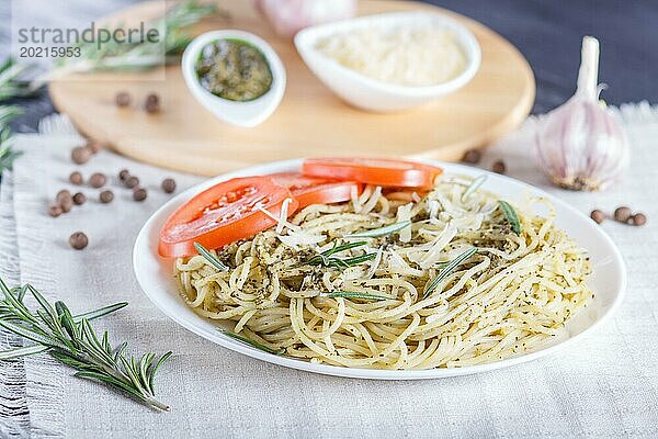 Spaghetti mit Pestosauce  Tomaten und Käse auf einer Leinentischdecke. Nahaufnahme  selektiver Fokus
