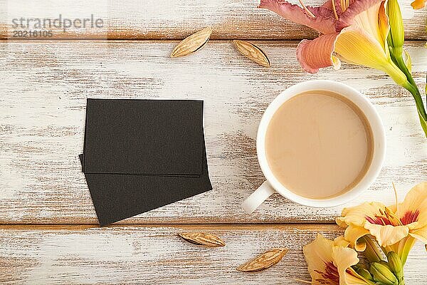 Schwarzes Papier Visitenkarte Mockup mit orange Taglilie Blume und Tasse Kaffee auf weißem hölzernen Hintergrund. Leer  Draufsicht  Flat Lay  Copy Space  Stillleben