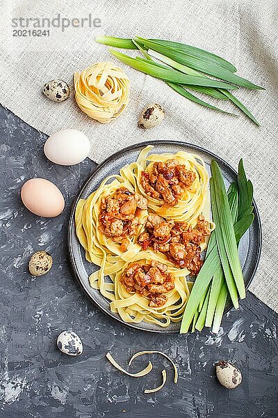 Tagliatelle Bolognese Nudeln mit Hackfleisch auf schwarzem Betonhintergrund. Ansicht von oben  flach gelegt