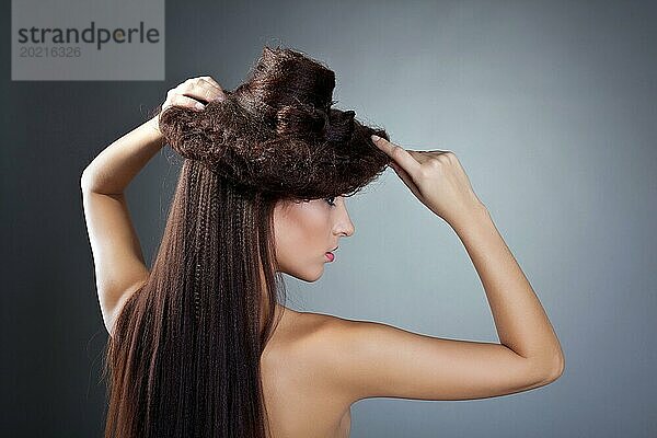 Attraktive nackte Schönheit Frau posiert mit Frisur Hut