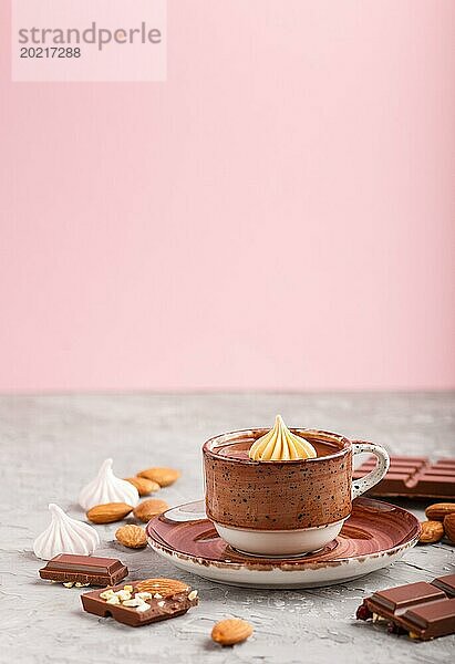 Tasse heiße Schokolade und Stücke von Milchschokolade mit Mandeln auf einem grauen und rosa Hintergrund. Seitenansicht  Nahaufnahme  selektiver Fokus  Kopierraum