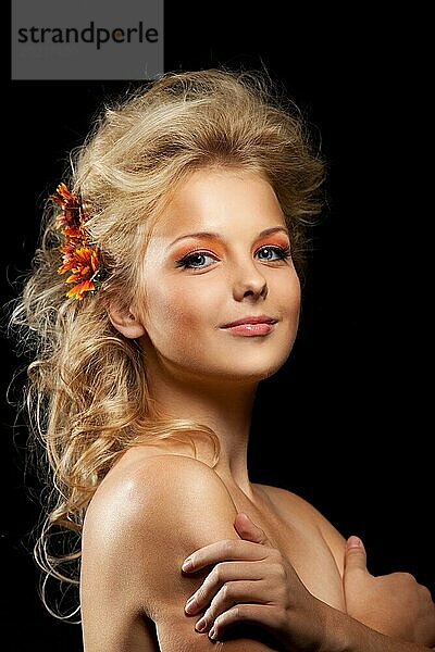 Schöne blonde Frau mit Blumengirlande im Dunkeln
