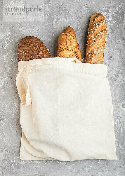 Wiederverwendbare Textil Lebensmittel Tasche mit frisch gebackenem Brot auf einem grauen Beton Hintergrund. Draufsicht  flat lay  copy space. zero waste concept
