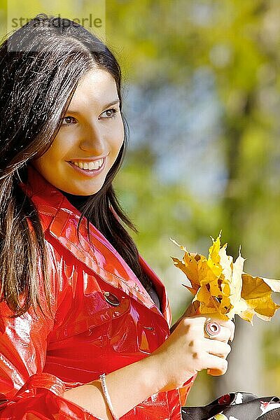 Junge Frau im herbstlichen Park mit gelben Blättern