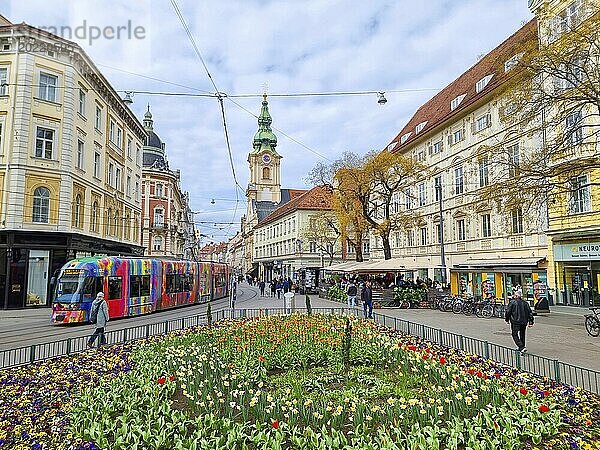 Graz  Österreich  26.03.2023: Bunte Frühlingsblumen auf dem Jakominiplatz und die Pfarrkirche im Hintergrund  eine berühmte Sehenswürdigkeit in der Stadt Graz  Steiermark  Österreich. Selektiver Fokus  Europa