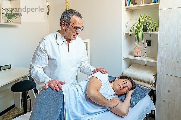 Entspannte Frau  die eine Massage von einem Qi Gong Experten in einer Klinik erhält
