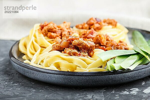 Tagliatelle Bolognese Nudeln mit Hackfleisch auf schwarzem Betonhintergrund. Seitenansicht  Nahaufnahme