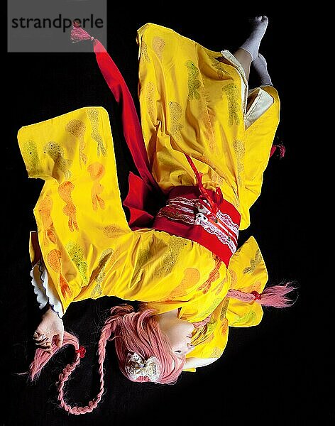 Porträt des jungen Mädchens lag in gelben Kimono Cosplay Kostüm