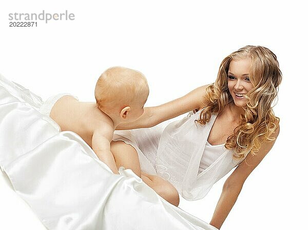 Schönheit blonde Mutter Blick auf spielerischen Sohn im Bett