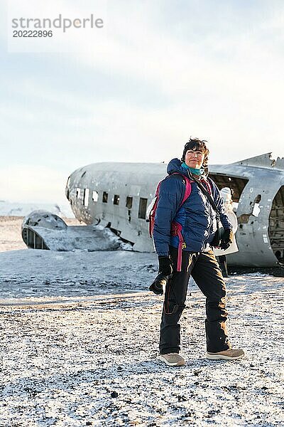 Porträt einer abenteuerlustigen Fotografin im Winter in Island im Flugzeug bei Solheimasandur