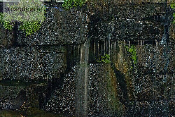 Nahaufnahme von Wasser  das an einer moosbewachsenen Steinmauer herabrieselt und eine heitere Atmosphäre schafft  in Südkorea