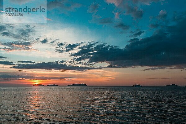 Schöne lila Sonnenuntergang auf dem Meer mit kleinen Inseln am Horizont