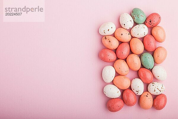 Bunte mehrfarbige Schokoladeneier Bonbons auf einem rosa Pastell Hintergrund. Karamell Dragees  Kopie Raum  Draufsicht  flat lay
