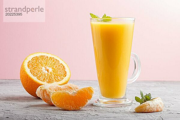 Glas Orangensaft auf einem grauen und rosa Hintergrund. Morninig  Frühling  gesundes Getränk Konzept. Seitenansicht  Nahaufnahme