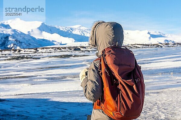 Eine Frau auf dem Rücken im winterlichen Island auf dem Breidarlon Gletscher neben dem Jokulsarlon