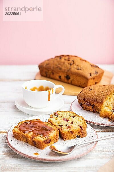 Hausgemachter Kuchen mit Rosinen  Mandeln  weichem Karamell auf einem weißen und rosa Hintergrund. Seitenansicht  Nahaufnahme  selektiver Fokus