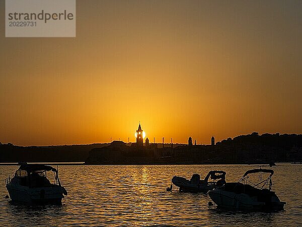 Boote ankern in einer Bucht  Abendrot bei Sonnenuntergang  Silhouette der Kirchtürme von Rab  Stadt Rab  Insel Rab  Kvarner Bucht  Kroatien  Europa